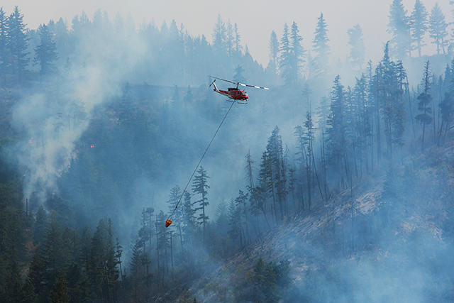 Helicopters drop water on the Blue Creek wildfire as it burns near Walla Walla, Wash., July 22, 2015. Officials warn about the potential for even more catastrophe in the months ahead, as drought, heat and climate change leave the landscape ever thirstier. (Ruth Fremson/The New York Times) 