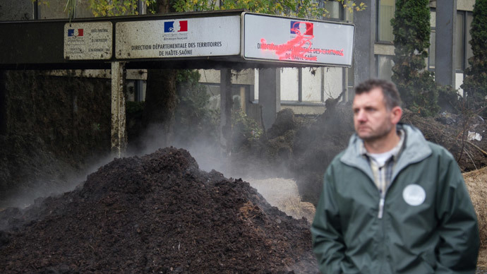 A farmer passes by the main entrance of the DDT (Direction Departementale des territoires) with a manure stacked outside during a protest in Vesoul, France on November 5, 2014.(AFP Photo / Sebastien Bozon)