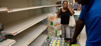 New York shoppers stock up on water from rapidly emptying shelves at a grocery store in Far Rockaway, N.Y., on Friday. (photo: Seth Wenig/AP)