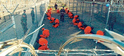 Guantanamo Bay detainees are made to kneel on the ground. (photo: Shane McCoy)