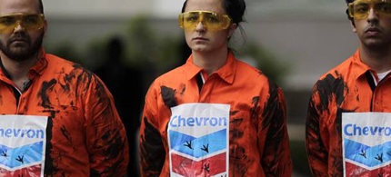 Greenpeace activists protest against an oil spill in waters off Rio de Janeiro state in front of Chevron headquarters in Rio de Janeiro, Brazil, 11/18/11. (photo: Luiza Castro/AFP/Getty Images)