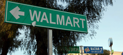 In Mexico, Wal-Mart advertises its stores on green signs, a color usually reserved for street signs nationwide. Other stores (like Bazar) abide by the policy to advertise via blue signs. (photo: Josh Haner/NYT)