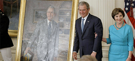 Former President George W. Bush and his wife, Laura, stand next to his portrait during a unveiling ceremony Thursday in the East Room of the White House in Washington. (photo: Charles Dharapak/AP)