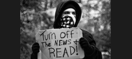 An Occupy protester urges peoples to turn off the news and read. (photo: Possible Futures)