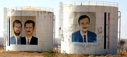 Oil tanks near the Syria-Iraq border decorated with pictures of past and present Syrian leaders. (photo: Richard Messenger)