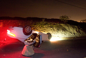 A car sits overturned on a highway in the Carbon Canyon area of Brea, California. Photo / AP