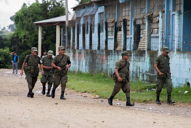 Two boys look on as Guatemalan soldiers patrol in the community of Santa Fe Ocaa in San Juan Sacatepquez during the state of exception. (Photo: Jeff Abbott)