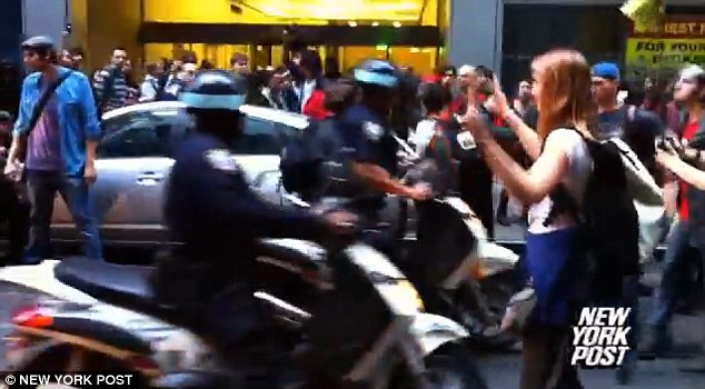 Antagonism: A woman taunts the officers, not letting them pass on their bikes