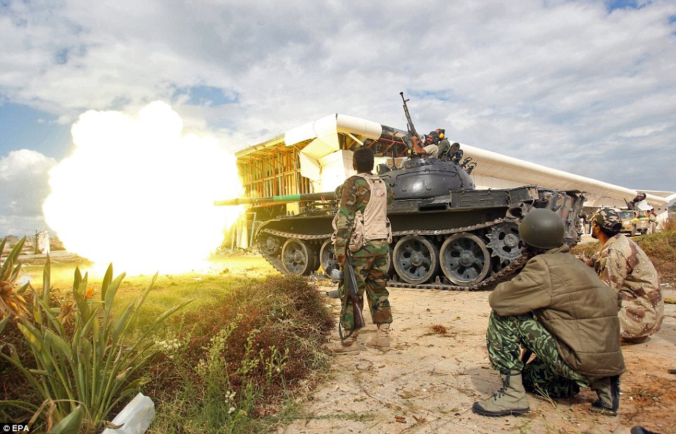 Attack: A tank of Libyan rebels fire at pro-Gaddafi fighters during the battle of Sirte