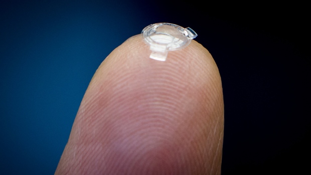 Dr. Garth Webb holds a bionic lens he developed on the tip of his finger. He says inserting it would be a painless procedure, identical to cataract surgery, that would take about eight minutes. A patient's sight would be immediately corrected.