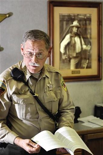 (AP Photo/Mail Tribune, Bob Pennell, File). FILE - In this undated file photo, Josephine County Sheriff Gil Gilbertson stands in his office in Grants Pass, Ore.