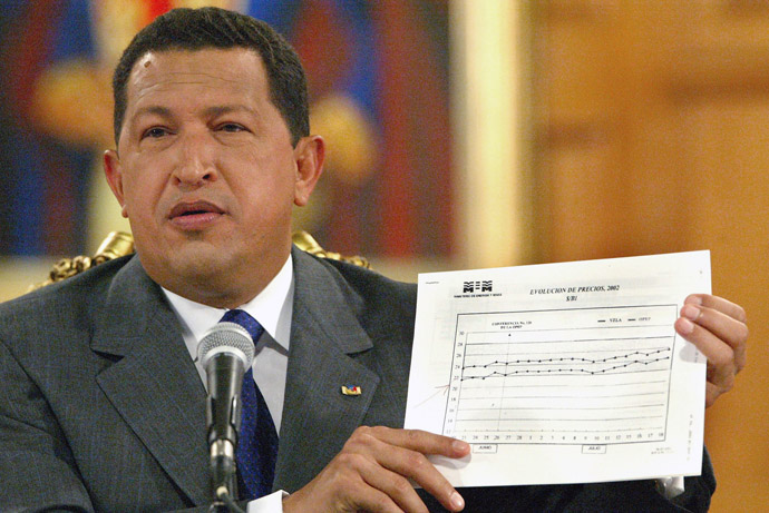 Venezuelan President Hugo Chavez displays a graphic with the evolution of oil prices during a press conference for the foreign media at Miraflores Presidential Palace in Caracas 18 July, 2002. (AFP Photo/Juan Barreto)