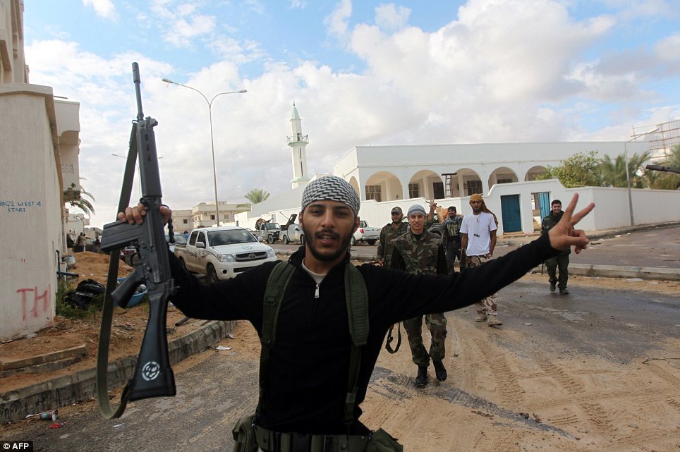 Confident: Rebel fighters flash the 'Victory' sign amidst the battle