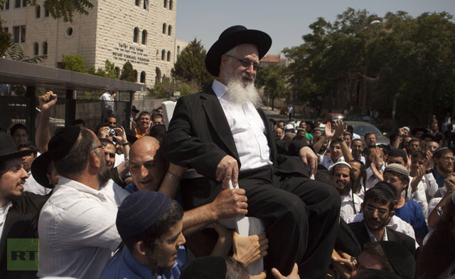 Jewish Orthodox supporters carry their rabbi Yaakov Yosef after his release following questioning by the Israeli police in Jerusalem.(AFP Photo / Menahem Kahana)