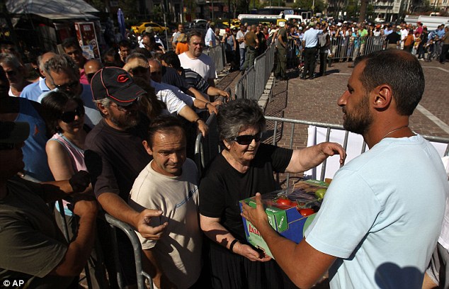 Lifeline: Hundreds of poverty-stricken Greeks are queuing for free vegetable handouts as politicians finally agree to form a coalition government
