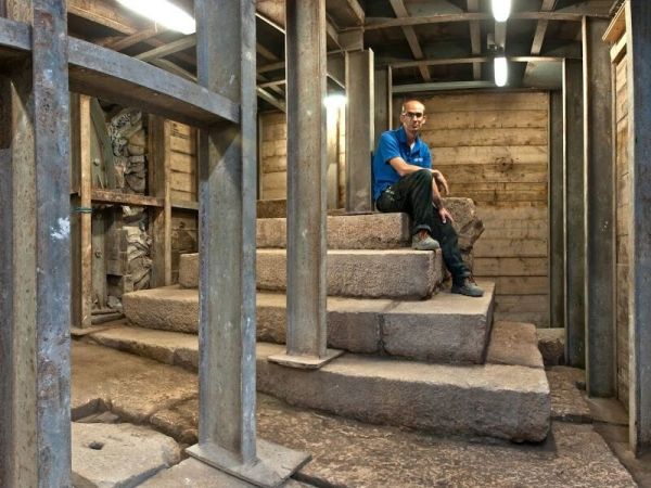  Joe Uziel, co-director of the excavation from the Israel Antiquities Authority, sitting atop the stepped structure from the Second Temple period. (Photo: Shai Halevy, courtesy Israel Antiquities Authority) 