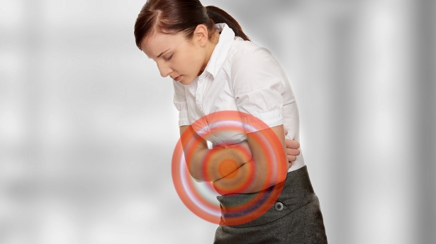 A woman experiences stomach pain. Photo: Shutterstock.com, all rights reserved.