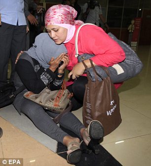 A relative of a passenger on the missing Sukhoi Superjet 100 aircraft cries as she is comforted after checking the passanger list at Halim Perdana Kusuma Airport in Jakarta, Indonesia