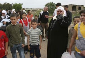 Syrian families carry their belongings as they arrive by foot in Wadi Khaled area, northern Lebanon