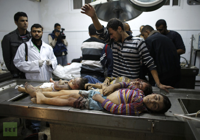 A Palestinian relative of four sibling children of the al-Dalo family, who were killed in an Israeli air strike, reacts as he stands next their bodies at a hospital in Gaza City November 18, 2012. (Reuters / Mohammed Salem)