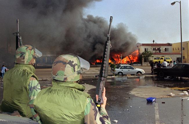 National Guardsmen watch a business go up in flames in South Los Angeles on April 30, 1992.